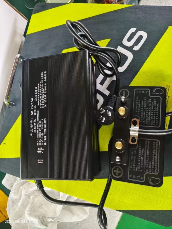 Rush Wave Dedicated Surfboard Charger, 56.8 V 15 A unit Rush Wave dedicated surfboard charger, a black 56.8 V 15 A lithium unit with its terminal plate.